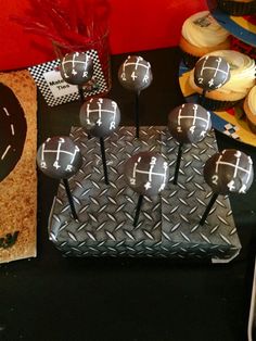 a table topped with cupcakes covered in black frosting and decorated with crosses