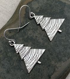 "These are perfectly festive and exquisitely detailed silver Christmas tree earrings. They are understated and classy. The perfect go to holiday earrings. These would make a very festive gift for a friend, loved one or secret Santa. The trees measure 1\" long by 3/4\" wide. They hang from simple silver ear wire hooks. Overall drop length is 1 1/8\". Made from allergy free plated silver. I have a matching necklace in my shop if you would like the whole set. Here is a direct linkhttps://etsy.me/32 Nickel Free Silver Earrings For Christmas, Nickel-free Silver Earrings For Christmas, Silver Holiday Drop Earrings, Holiday Silver Drop Earrings, Silver Drop Earrings For Holidays, Silver Jewelry For Festive New Year, Christmas Silver Jewelry With Matching Earrings, Handmade Silver Holiday Earrings, Holiday Nickel-free Silver Earrings