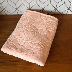 a pink towel sitting on top of a wooden table