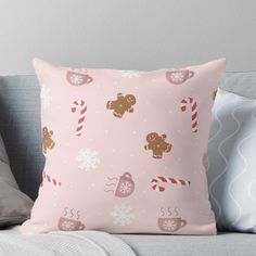 a pink pillow with gingerbreads and candy canes on it