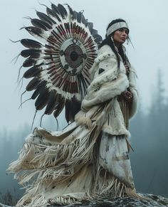 a native american woman standing on top of a hill with an eagle feather headdress