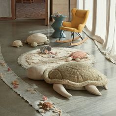 a child's room with stuffed animals on the floor and rugs around it