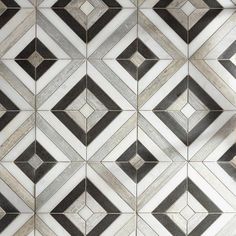 a black and white tiled wall with geometric designs on it's sides, as well as the floor