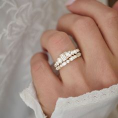 a close up of a person's hand wearing a ring with three stones on it