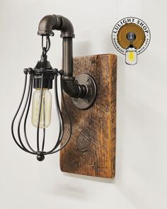 an old fashioned light fixture is mounted on the wall next to a wooden plaque that reads,