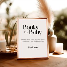 there is a sign that says books for baby on the table next to some candles