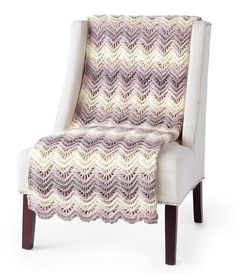 an upholstered chair with a crocheted blanket on it's back