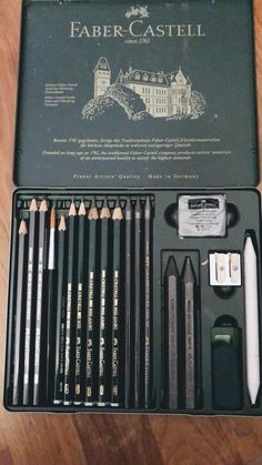 an assortment of different colored pencils in a black case on a wooden table with writing utensils