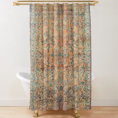 a shower curtain with an orange, blue and green floral design on it next to a white bathtub