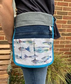 a person wearing a blue and white bag with fish on it's back pocket