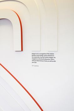 a white wall with red lines on it and an orange line in the center that says,