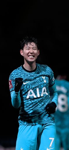 a soccer player is smiling and holding his hands in the air