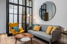 a living room filled with furniture and a round mirror