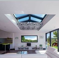 a living room filled with furniture and a flat screen tv mounted to the wall above it