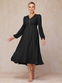 a woman is wearing a black dress with long sleeves and buttons on the front, while she