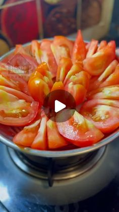 a metal bowl filled with sliced tomatoes on top of a stove