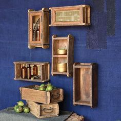 several wooden boxes with bottles on them and some fruit in the bottom one is empty