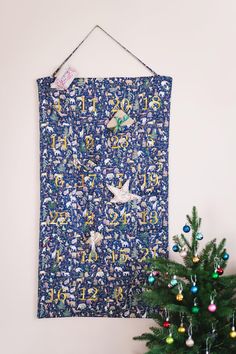 a christmas tree next to a blue wall hanging