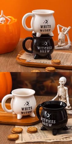 three white and black coffee mugs sitting on top of a wooden table next to cookies