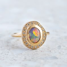 Our Pebble collection of raw, rough, beaten metals set with precious gems. Perfectly imperfect and all one of a kind. A Lightning Ridge black opal has been set into our Pompeii Ring with a surround of G/VS white brilliant cut diamonds. Black opal measures 8 x 6mm. Diamond halo weight 0.18ct. Top of ring measures 14 x 1 Sarah Gardner, Pebble Collection, Unique Opal Ring, Lightning Ridge Black Opal, Crystals Jewelry, Lightning Ridge, Pompeii, Precious Gems, Opal Ring