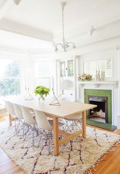 a dining room table with chairs and a fire place in the corner, next to a fireplace