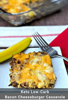 a white plate topped with a casserole covered in cheese next to a pickle