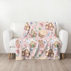 a couch covered in a pink blanket with cupcakes and candies on it