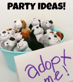 a bowl filled with stuffed animals next to a sign that says adopt - a - puppy party ideas