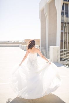 a woman in a white dress is walking down the street with her dress blowing in the wind