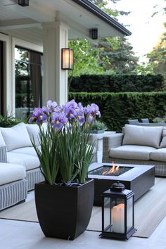 a living room filled with furniture and flowers on top of a white floor next to a fire pit