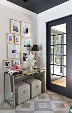 an entryway with pictures on the wall and two stools in front of it