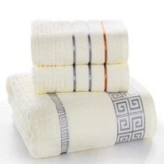 three towels stacked on top of each other in white and orange colors with greek designs