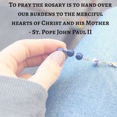 a person holding a rosary with a quote about it on the back of their lap