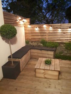 a wooden bench sitting on top of a hard wood floor next to a planter