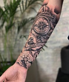 a man's arm with a clock and compass tattoo on it