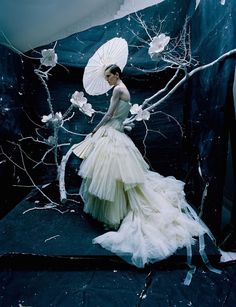 a woman in a white dress holding an umbrella