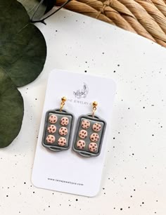 a pair of earrings with chocolate chip cookies on them