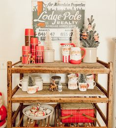 a wooden shelf filled with christmas decorations and mugs on top of eachother