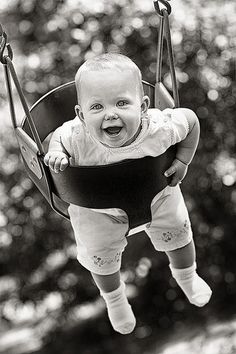 a baby is sitting in a swing outside