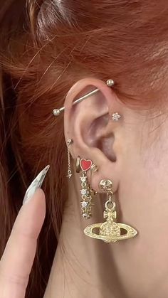 a close up of a person wearing ear piercings and holding onto an earring