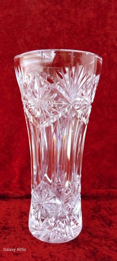 a clear glass vase sitting on top of a red table