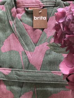 pink and green floral print dress with name tag on label, closeup view from the waist up