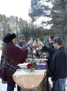 a group of people standing around a table holding wine glasses