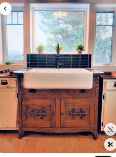 an old fashioned kitchen sink in the middle of a wood floored area with windows