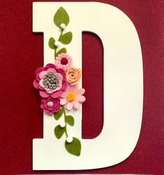 the letter d is decorated with flowers and leaves