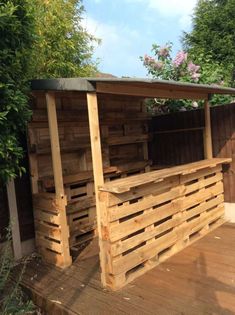 an outdoor bar made out of pallets and wooden planks on a deck outside