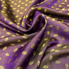 a purple and gold fabric with small flowers on the top, as well as yellow leaves