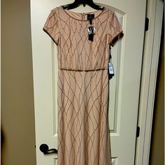 a dress hanging up on a door with a tag attached to it's chest