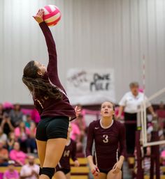 a volleyball player jumping up to hit the ball