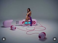 a woman sitting on top of a pink electronic device